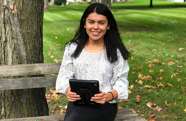Melissa Vega sitting on bench with digital tablet